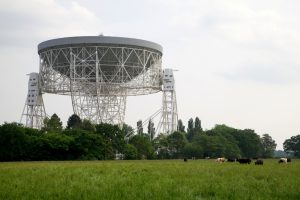 The Lovell Radio Telescope at the Jodrell Bank Center for Astrophysics, part of the University of Manchester, viewed from across the fields of a neighbouring farm.